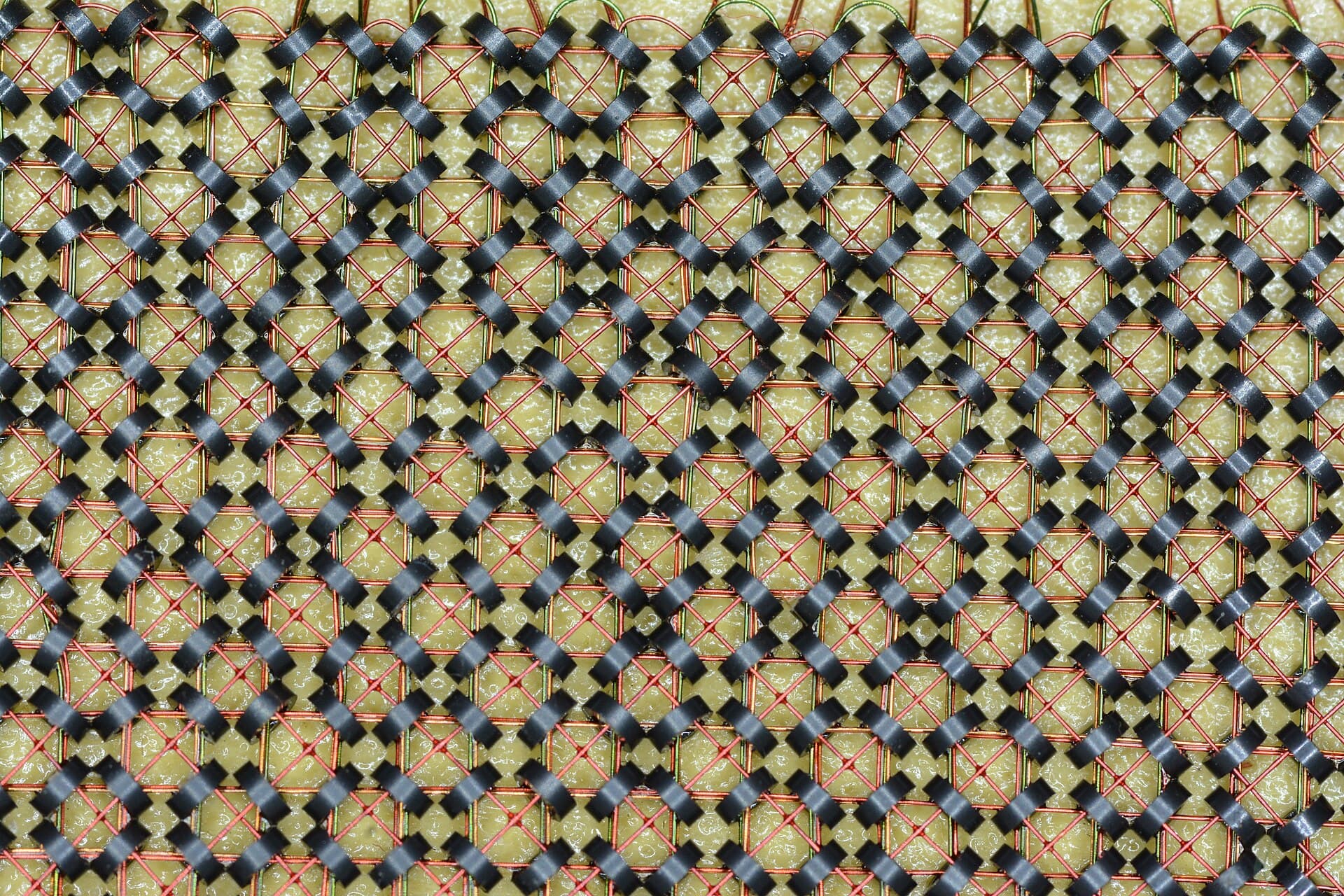 Close-up of magnetic-core memory: tiny ferrite rings threaded on a grid of fine copper wires